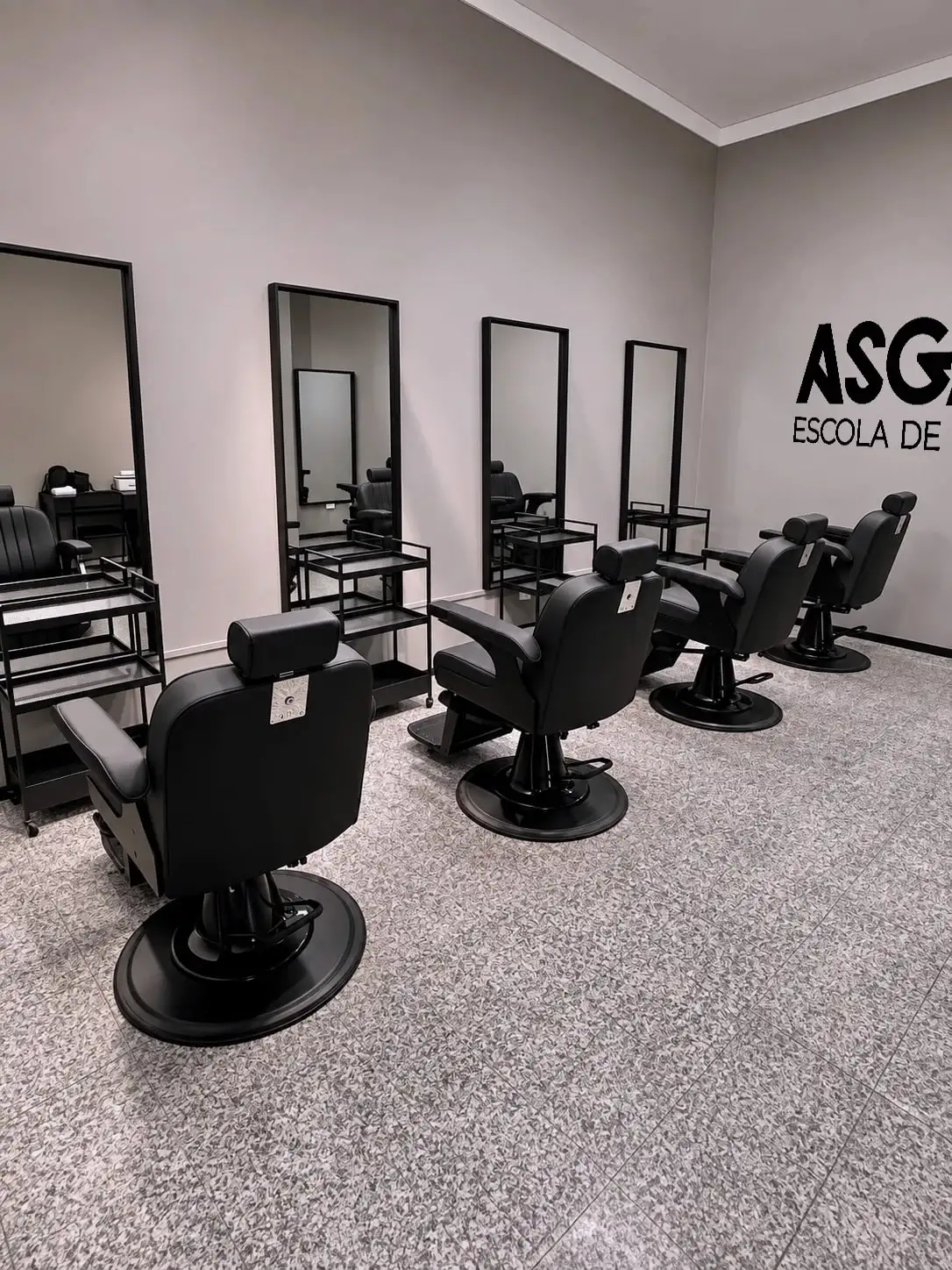 Sala da Asgard Barber School com cadeiras e espelhos