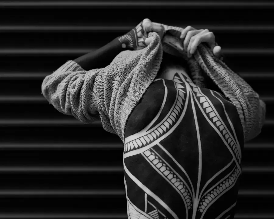 Tatuagem blackwork com grandes áreas pretas e linhas nas costas