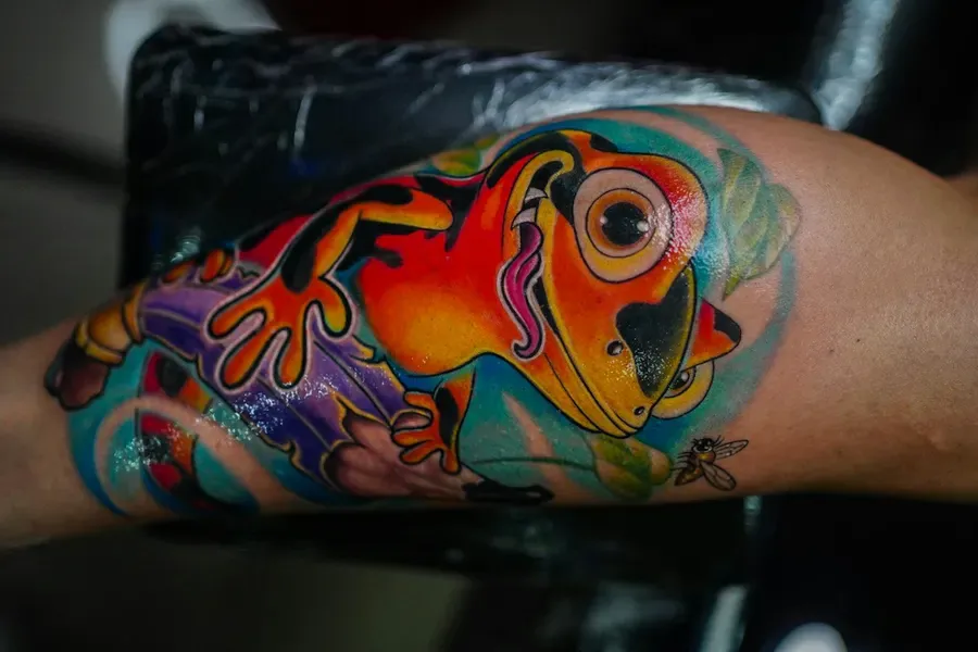 Tatuagem neotradicional de um sapo colorido no braço