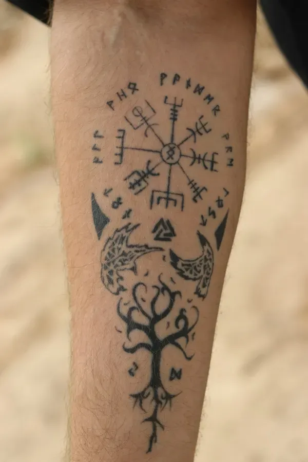 Tatuagem nórdica com o Vegvísir, runas e a árvore Yggdrasil no antebraço